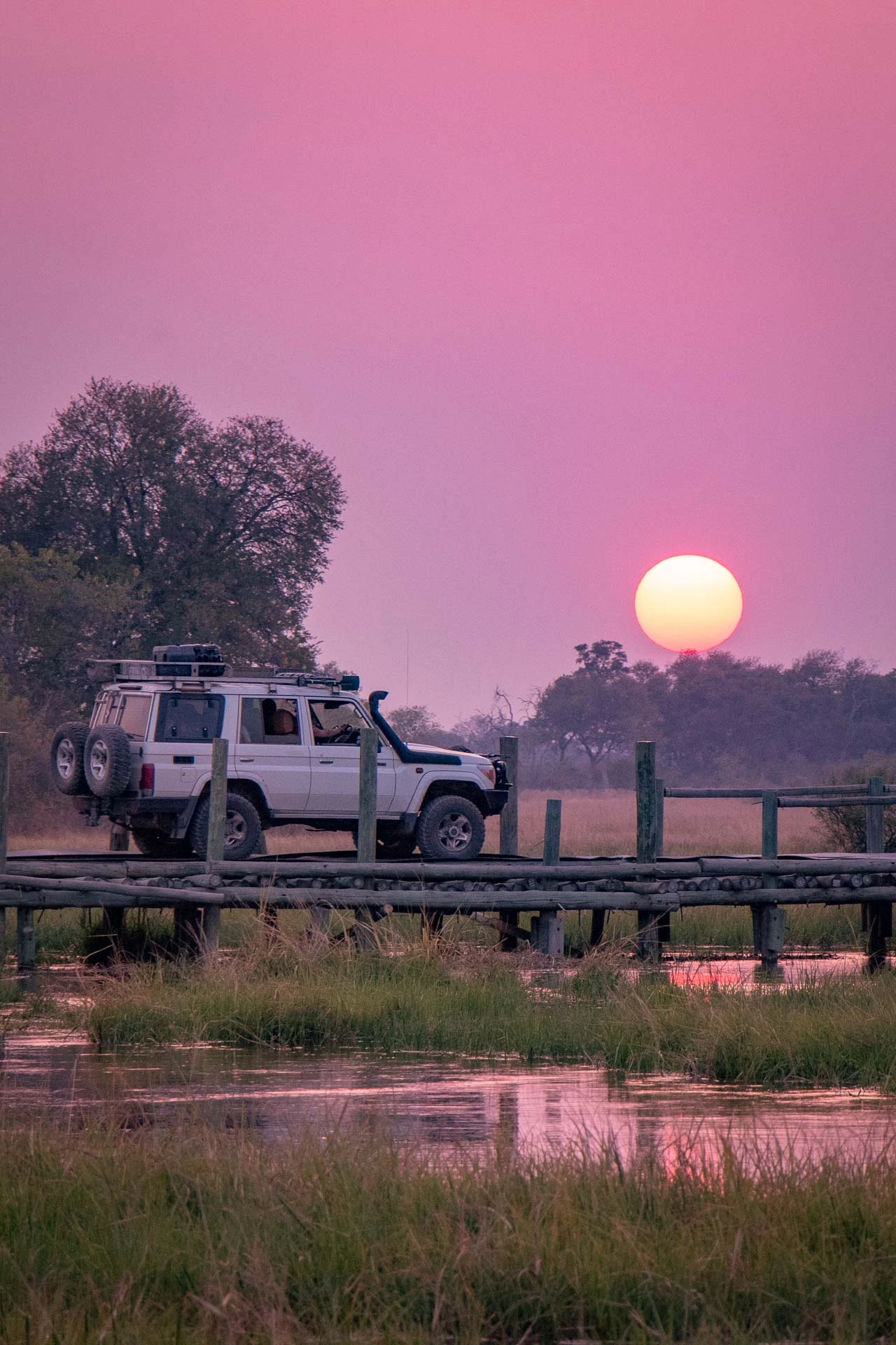 Overland vehicle on bridge in Botswana at sunset
