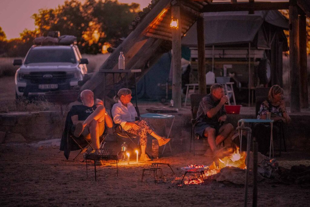 Endless Africa clients sitting around campfire at Mabuasehube